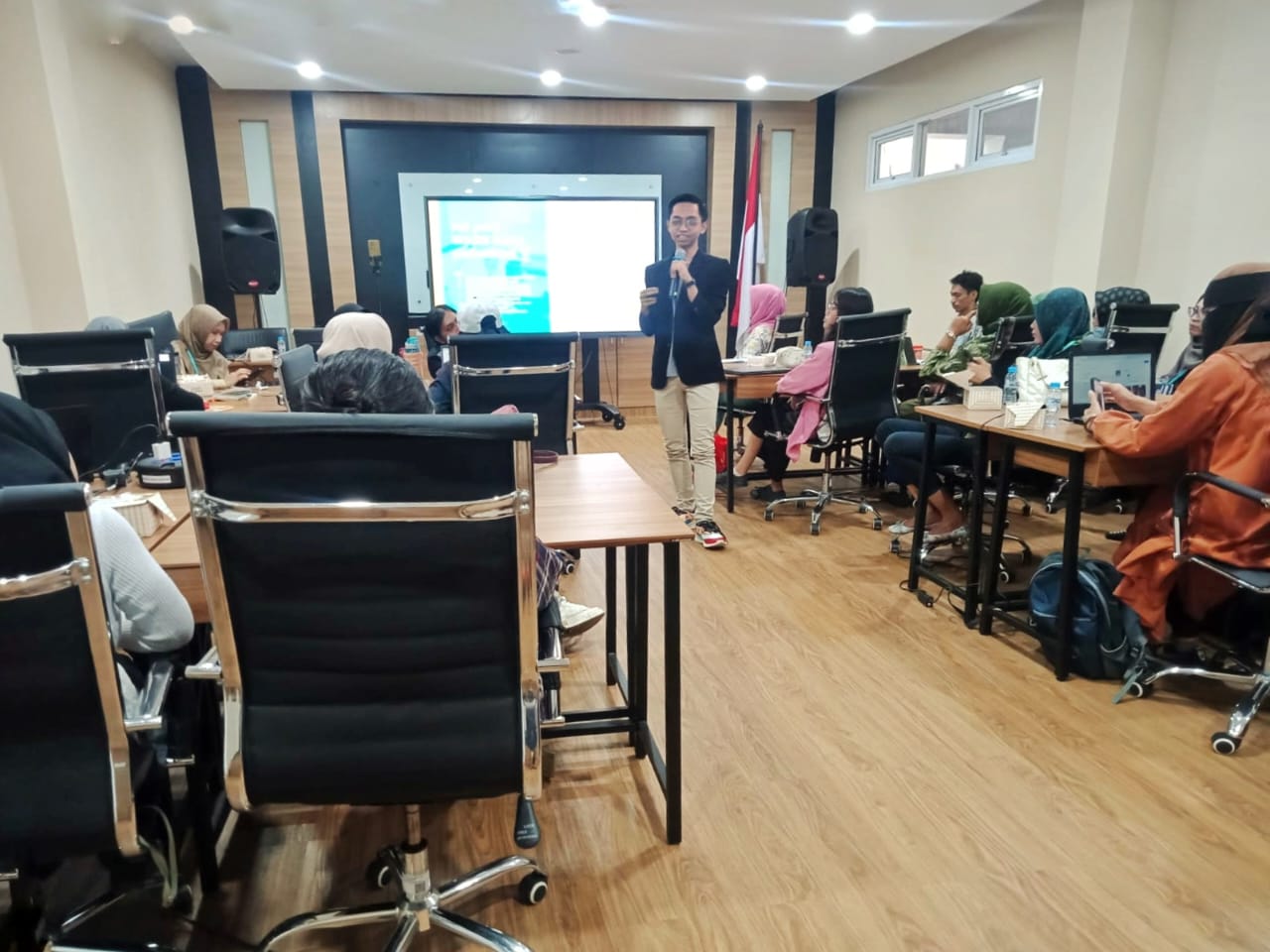 Trainer menyampaikan materi di depan peserta workshop